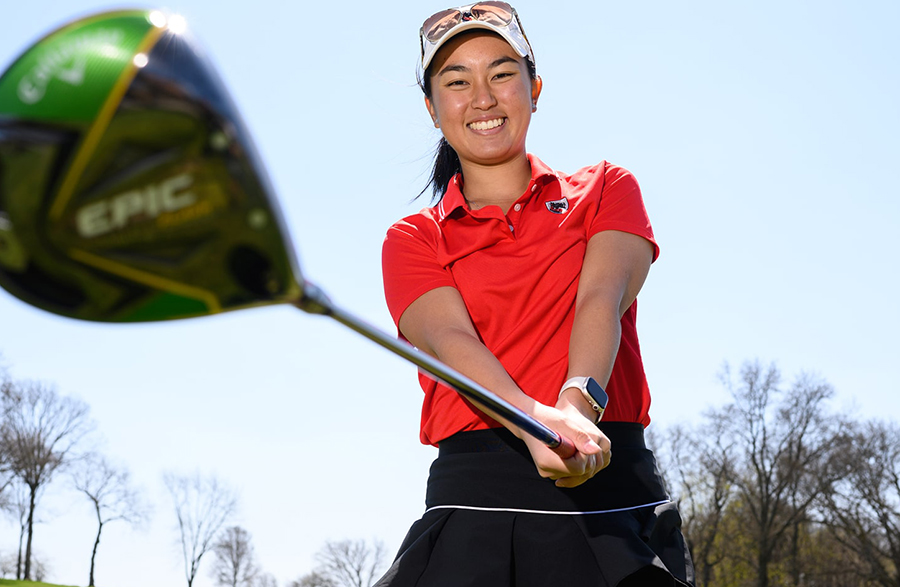 Portrait of Nadia Susanto with a golf club.
